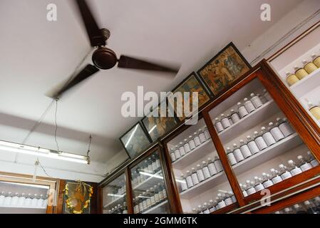 Aranmula, India - 5 dicembre 2015: Farmacia Ayurveda reale in Kerala. Trattamento tradizionale della malattia in Asia. Scaffali con bottiglie e prodotti medicinali Foto Stock