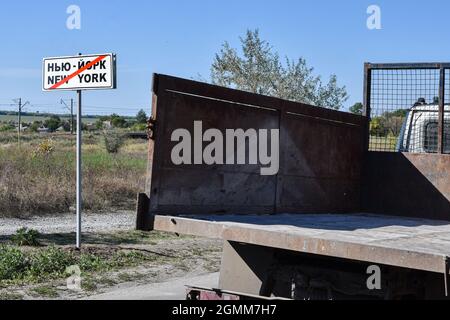 New York, Ucraina. 16 settembre 2021. Un camion guida oltre un cartello stradale di New York alla fine del territorio di insediamento. New York (ex Novgorodske 1951-2021) è un insediamento urbano nella regione di Donetsk, situato in prima linea della guerra dell'Ucraina con separatisti russi. il Parlamento ucraino il 1° luglio 2021 rinominò Novgorodske di nuovo a New York come prima del 1951. Credit: SOPA Images Limited/Alamy Live News Foto Stock