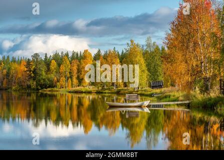 Lago d'acqua calmo con un riflesso della foresta colorata autunno in Finlandia Foto Stock