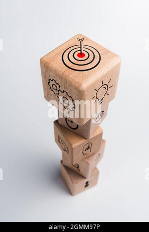 Strategia aziendale con processo di successo della crescita per il concetto di leadership e lavoro di squadra. Il piano d'azione, l'icona del bersaglio di affari sui blocchi di cubo di legno sta Foto Stock