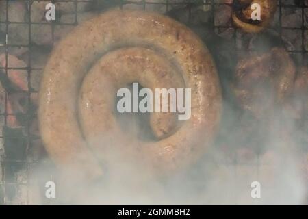 Serpentina di salsiccia in stile sudafricano grigliata su un barbecue, vista dall'alto Foto Stock