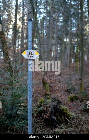 cartello per escursionisti nella foresta. due persone disegnate con frecce gialle e bianche che puntano a destra e a sinistra Foto Stock