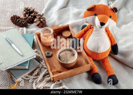 Hygge ancora vita con un giocattolo volpe, una tazza di caffè, e candele profumate. Accogliente week-end mattina, soggiorno a casa in clima freddo Foto Stock