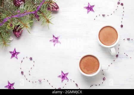 Due tazze di cioccolata calda e decorazioni natalizie su tavola di legno bianco. Disposizione piatta; Foto Stock