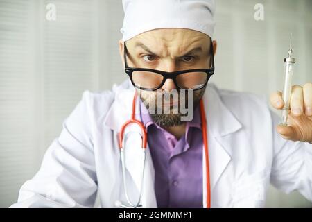 Un uomo con occhi incrociati sta guardando nel telaio. Malattia oculare. Il concetto di medico specialista pazzo. Vicino medico. Foto Stock