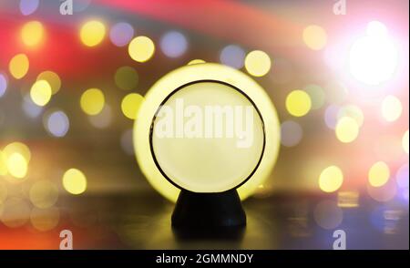 Sfera di cristallo sul pavimento con bokeh. Palla di vetro con luce bokeh colorata, concetto di festa di nuovo anno. Foto Stock