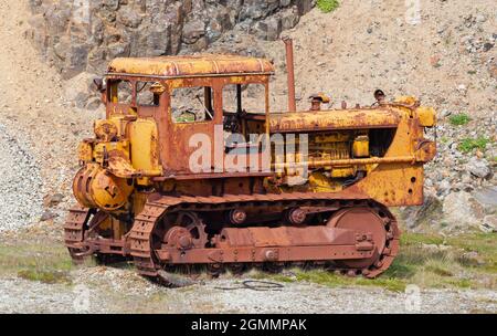 Vecchio trattore cingolato arrugginito con pala, Islanda Foto Stock