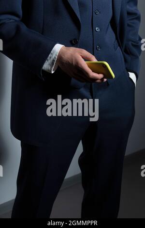 Uomo d'affari in tuta con smartphone Foto Stock
