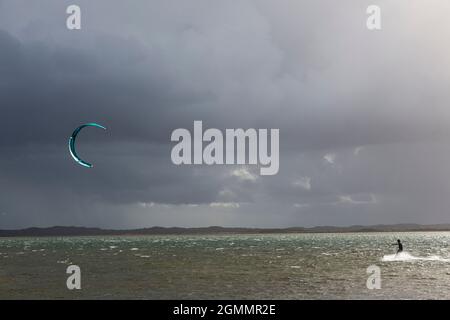 Kite Boarder sull'oceano sotto il cielo nuvoloso e tempestoso Foto Stock