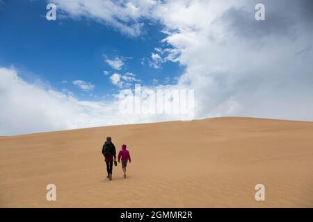 Madre e figlio camminando lungo dune di sabbia remote, Wilsons promontorio, Victoria, Australia Foto Stock