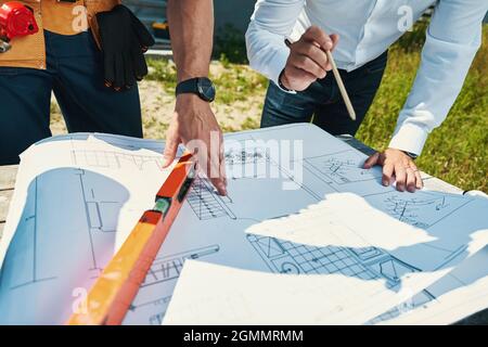 Due persone che esaminano la disposizione della casa insieme all'aperto Foto Stock