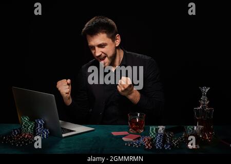 Uomo bearded del giocatore in linea del casino che celebra la vittoria Foto Stock