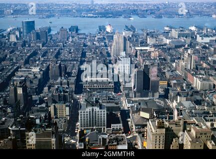 New York City, USA – una vista verso ovest sulla città verso il fiume Hudson e i moli della città 1954. La strada che attraversa da sinistra a destra in primo piano è Broadway con un cartello per il Capitol Theatre (nota l'ortografia britannica del cartello) in alto sul livello della strada. Un transatlantico è ormeggiato in porto su uno dei moli. Questa immagine proviene da una vecchia trasparenza del colore Kodak presa da un fotografo dilettante – una fotografia d'epoca anni '50. Foto Stock