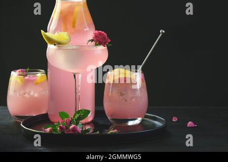 Cocktail freschi con gin di rose e limone su sfondo nero. Limonata rinfrescante per feste. Primo piano. Foto Stock