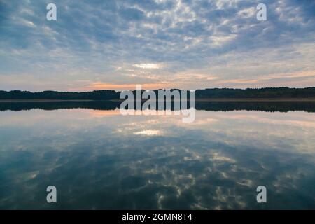 Umore mattina al lago Breiter Luzin, le nuvole si riflettono nell'acqua, Germania, Meclemburgo-Pomerania occidentale, Parco Naturale Feldberger Foto Stock