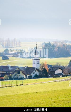 Villaggio di montagna austriaco soleggiato con fondo valle nebbiosa durante l'autunno a Wildermieming, Tirolo, Austria Foto Stock