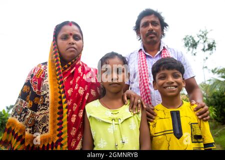 I genitori rurali indiani e i loro due figli in piedi in villaggio Foto Stock