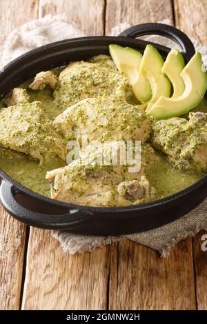 Lo stufato di pollo verde guatemalteco è più comunemente noto come stufato di pollo con i tomatillos in primo piano nel piatto sul tavolo. Verticale Foto Stock