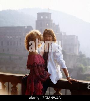 Bernd Clüver, deutscher Schlagersänger, mit Ehefrau Ute Kittelberger in der Grünanlage rund um das alte Schloss in Heidelberg, Deutschland um 1982. Il cantante tedesco Bernd Cluever con la moglie Ute Kittelberger nel parco pubblico intorno al castello di Heidelberg, Germania, intorno al 1982. Foto Stock