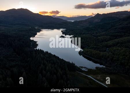 Loch Achray, Aberfoyle e Loch Achray, Loch Lomond e Trossachs National Park, Scozia, Regno Unito. 19 Settembre 2021. NELLA FOTO: Vista del drone Loch Achray e sulla strada conosciuta come Dukes Pass che è la A821 che collega il cuore turistico molto popolare 200 Route. Si tratta di un'area affollata da appassionati di attività all'aria aperta e da turisti che vogliono fuggire dalla città e entrare nella panoramica campagna scozzese. Credito: Colin Fisher Foto Stock