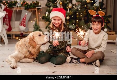 Bambina e ragazzo che reggono scintille Foto Stock