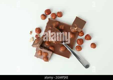 Cucchiaio con pasta di cioccolato e cioccolato con noci su sfondo bianco Foto Stock