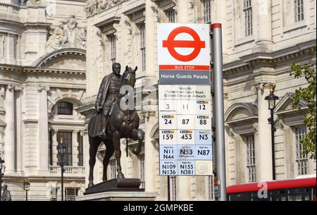 Londra, Inghilterra, Regno Unito. Segnale della fermata dell'autobus per la Parata delle Guardie Cavallo a Whitehall - statua di Earl Haig alle spalle Foto Stock