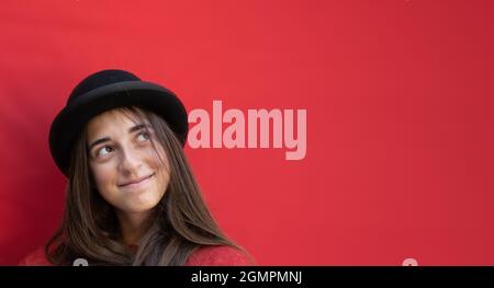 Ritratto ragazza adolescente su sfondo rosso. Foto orizzontale, atmosfera natalizia con spazio per la copia Foto Stock