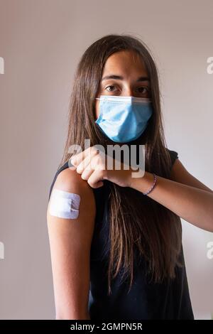 Ragazza vaccinata giovane con bendaggio adesivo dopo l'iniezione. Medicina Healthcare prevenzione del Covid Foto Stock