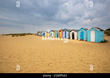 Colorate capanne sulla spiaggia tra le dune di sabbia a Southwold, Suffolk, Inghilterra Foto Stock