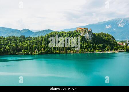 Castello medievale di Bled sulla scogliera della montagna sotto il lago di Bled con acqua turchese in Slovenia Foto Stock