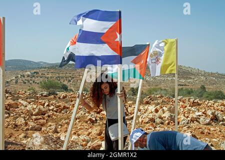 Nablus, Palestina. 20 Settembre 2021. I manifestanti palestinesi sono visti costituire bandiere di paesi che sostengono la causa palestinese. I manifestanti palestinesi si riuniscono nel campo delle Nazioni Unite, istituito da attivisti palestinesi e stranieri per protestare contro la creazione di avamposti ebrei illegali sulle terre palestinesi nella città di Salfit, nella Cisgiordania settentrionale. Credit: SOPA Images Limited/Alamy Live News Foto Stock