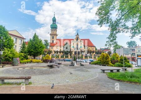 Tychy, Polonia - 5 giugno 2021: Piazza del mercato con fontana con lontre e chiesa di Santa Maria Maddalena sullo sfondo. Foto Stock