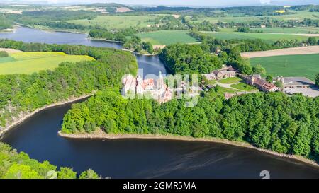 Vista aerea panoramica del misterioso castello medievale di Czocha nel Voivodato inferiore della Slesia, nel sud-ovest della Polonia. Il castello si trova sul lago le Foto Stock