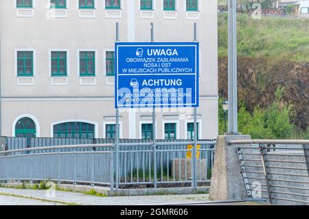 Zgorzelec, Polonia - 2 giugno 2021: Informazioni in polacco e tedesco sull'obbligo di indossare maschere in relazione alla pandemia COVID-19. Segno a Foto Stock