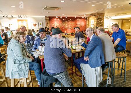 Londra Inghilterra,Regno Unito Kensington Pret A Manger cafe Restaurant,anziani cittadini amici uomini donne parlare Foto Stock