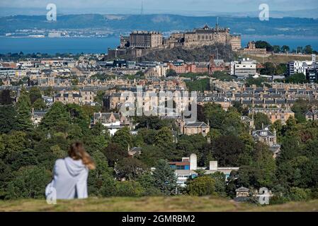 Vista del Castello di Edimburgo con una figura fuori fuoco in primo piano, presa da Blackford Hill, Edimburgo, Scozia, Regno Unito. Foto Stock