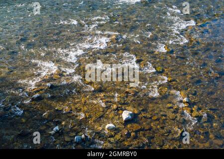 Acqua cristallina su letto di ruscello e ciottoli colorati. Foto Stock