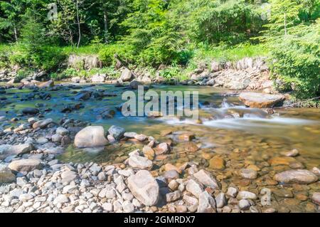 Vista estiva sul torrente roccioso Czarna Wiselka con lunga esposizione. Foto Stock