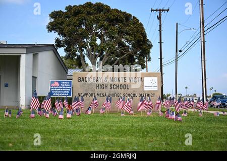 Piccole bandiere americane sono posti intorno alla segnaletica a Back Bay e Monte Vista High School, Martedì, Agosto 31, 2021, a Costa Mesa, Calif. Le bandiere erano p Foto Stock