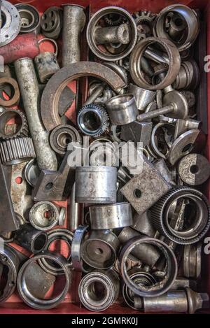 Scatola di dadi e bulloni a caso, parti, rondelle, viti in officina. Foto Stock