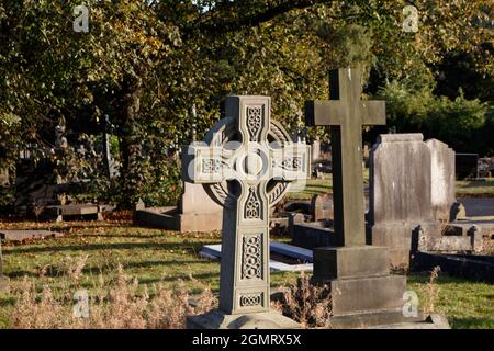 Croce celtica testa di pietra in un cimitero Foto Stock