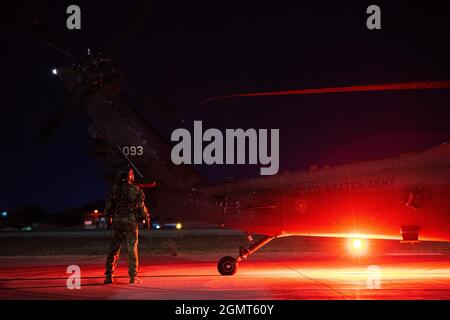 Un soldato dell'esercito degli Stati Uniti assegnato al gatto nero della Task Force ispeziona un falco nero UH-60 prima di una missione di addestramento congiunta dell'elicottero K-9 alla base aerea di Incirlik, Turchia, 13 settembre 2021. Durante la missione, i movimentatori di cani militari del 39° Squadron delle forze di sicurezza hanno condotto evacuazioni mediche sulle vittime simulate del K-9 e su altre attività specifiche della missione necessarie per le operazioni nel mondo reale. Questo addestramento interservizi con l'esercito degli Stati Uniti ha permesso loro di acclimatare i loro K-9 alle operazioni dell'elicottero in condizioni di combattimento. Task Force Black Cat garantisce la mobilità del guerriero congiunto in supporto Foto Stock