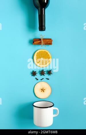 VIN brulé ingredienti, ancora vita su sfondo blu. Bottiglia di vino, bastoncini di cannella, fette di arancia, mela, anice e tazza. Concetto culinario reci Foto Stock