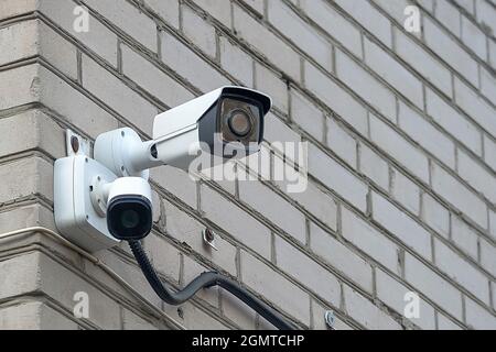 La telecamera CCTV si trova sul muro di mattoni della casa Foto Stock