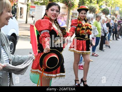 Duisburg, Germania. 18 settembre 2021. I ballerini dell'associazione 'amici della Bolivia' formano una catena umana insieme ai cittadini di Duisburg nel centro della città. Le organizzazioni avevano chiesto l'azione "anelli di vita per i diritti umani”. La catena doveva essere formata da Amburgo, passando per Stoccarda, fino al Mediterraneo per richiamare l'attenzione sui diritti umani dei rifugiati alle frontiere esterne dell'Unione europea e nel Mediterraneo. Credit: Roberto Pfeil/dpa/Alamy Live News Foto Stock