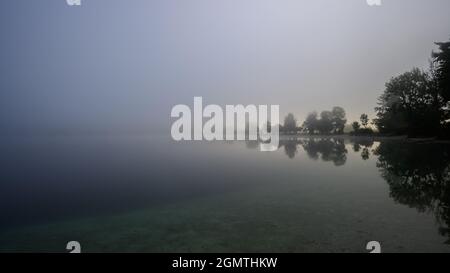 Nebbia sul lago di Bohinj all'alba Foto Stock