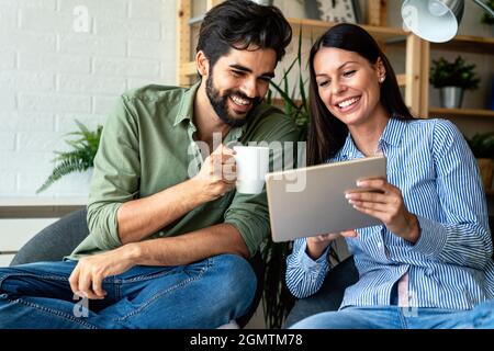 In coppia d'amore che usa un computer tablet nel loro soggiorno. Tempo libero insieme. Foto Stock