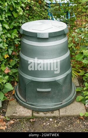 Bidone verde rotondo composto fatto di plastica riciclata in un giardino. Concetto di riciclaggio ed eco-compatibile. Foto Stock