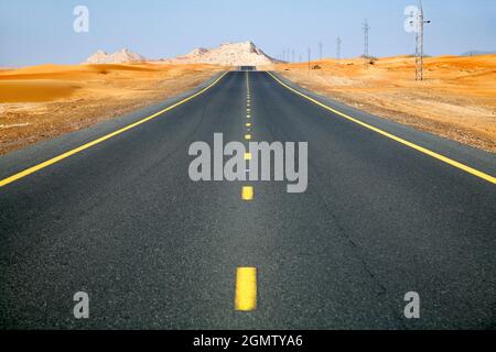 Dubai, Emirati Arabi Uniti - Febbraio 2008; una strada desertica infinita e vuota fuori dalla città di Dubai, conduce al deserto e, in ultima analisi, al Quart vuoto Foto Stock